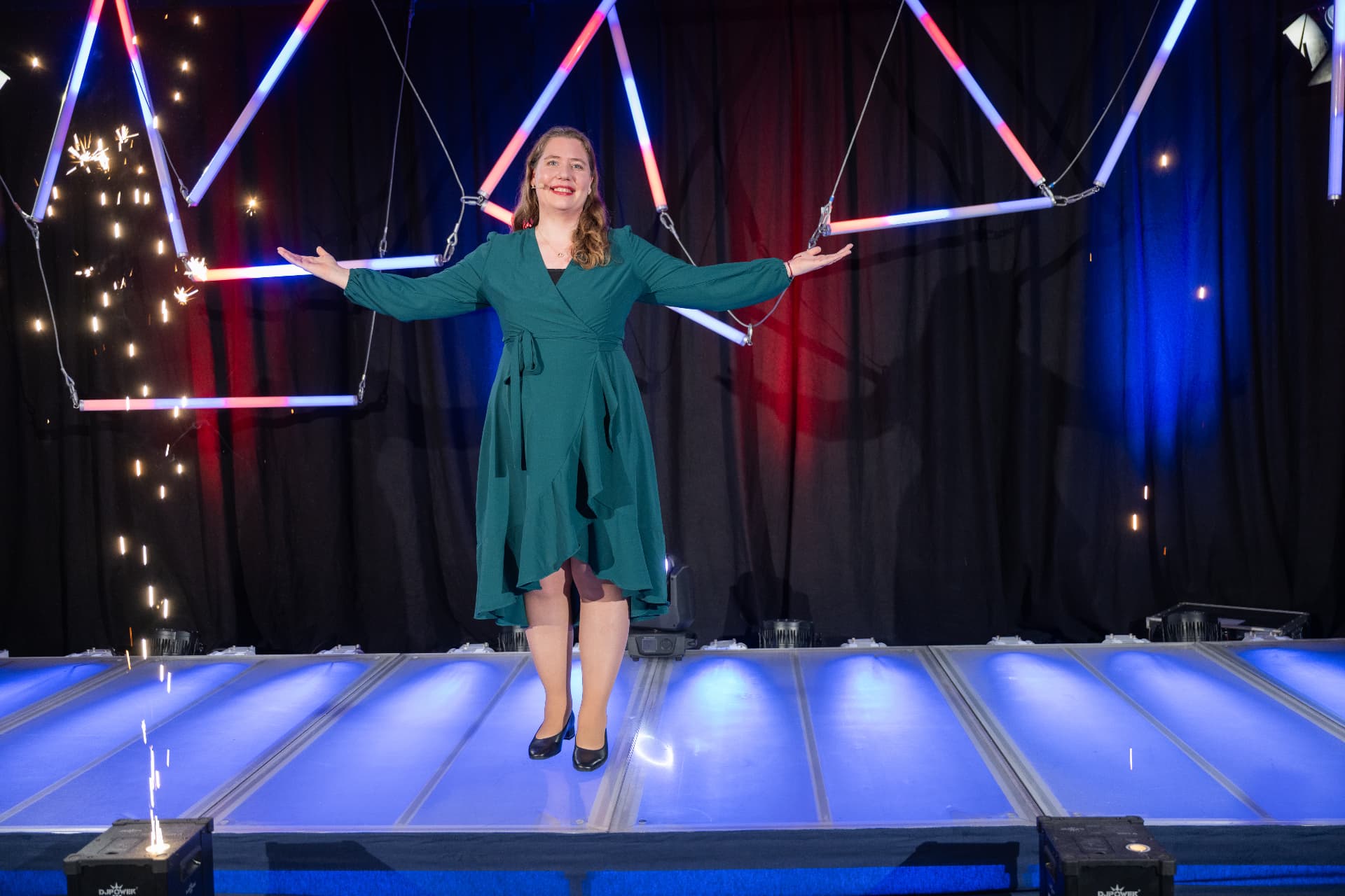 Ariane Krahl auf der Bühne, umgeben von Licht und Funken
